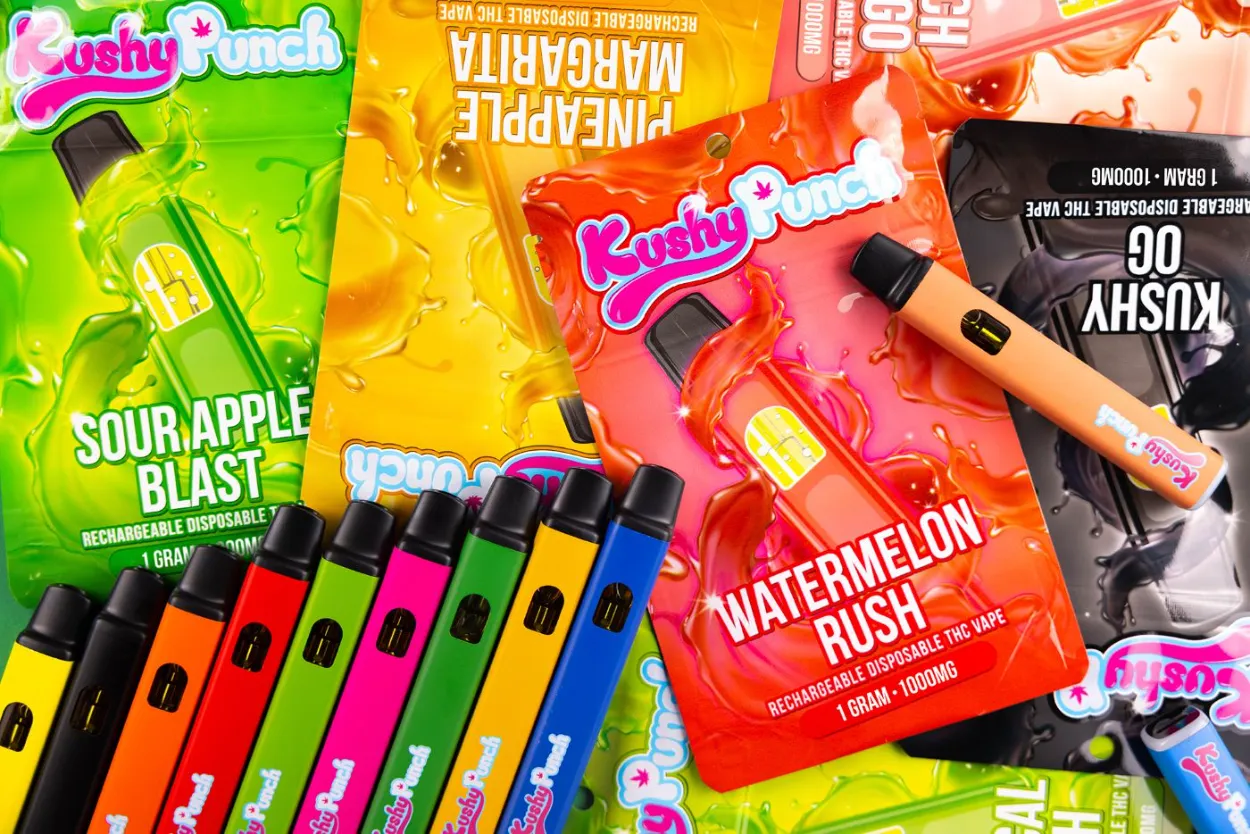 Colorful cannabis edible products and vape pens arranged on display surface