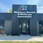 # Alt Text

Exterior storefront of Missouri cannabis dispensary with dark gray metal siding and entrance doors